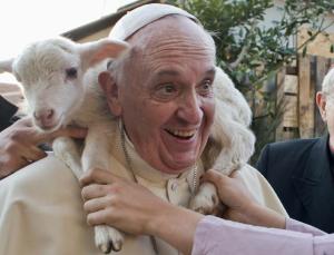 A woman dressed as a character from the nativity scene puts a lamb around the neck of Pope Francis as he arrives to visit the Church of St Alfonso Maria dei Liguori in the outskirts of Rome