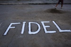 A woman walks by a the word 'Fidel' written on the asphalt near the route made by the motorcade carrying Fidel Castro's ashes to the the Santa Ifigenia cemetery in Santiago, Cuba Sunday, Dec. 4, 2016. Thousands of people lined the short route from the Plaza Antonio Maceo or Plaza of the Revolution to the cemetery where the ashes will be buried in a private ceremony near the grave of Cuba's independence hero Jose Marti. (ANSA/AP Photo/Rodrigo Abd) [CopyrightNotice: Copyright 2016 The Associated Press. All rights reserved.]