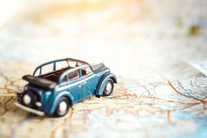 Toy retro cabrio car on the map, tourism concept