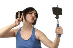 donna-sexy-che-prende-la-foto-del-selfie-con-la-posa-della-macchina-fotografica-del-telefono-cellulare-e-del-bastone-felice-87518619