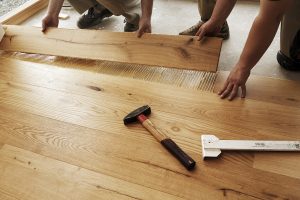 Two men laying finished parquet flooring, close-up