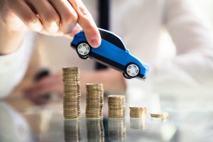 Person Flying Car Over Declining Stacked Coins