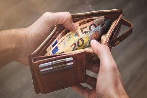 Hands opening a leather wallet with Euro banknotes inside